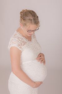 Babybauch mit wei&szlig;em Kleid